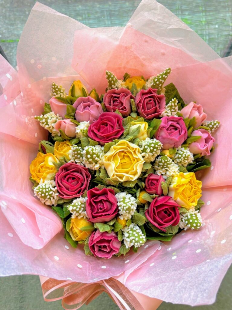 A floral cupcake bouquet of yellow, pink and red rosebuds
